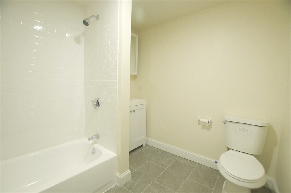 501 East Broadway, Unit 2 Boston, MA 02127 - Photo 3 of 8 a white toilet sitting next to a bath tub