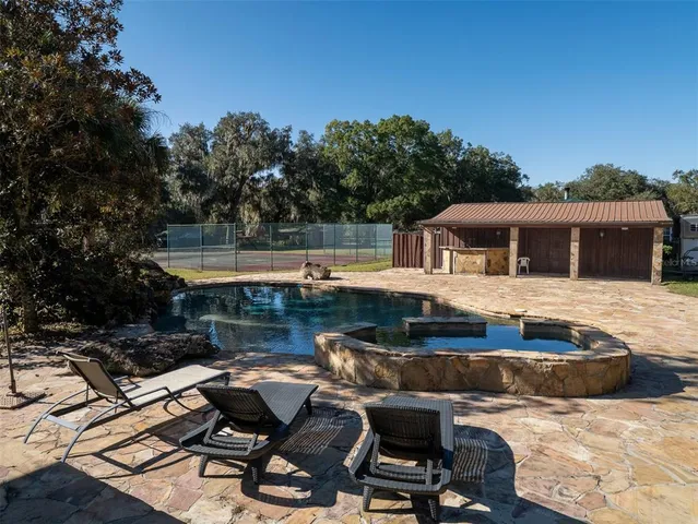 a view of a backyard with swimming pool
