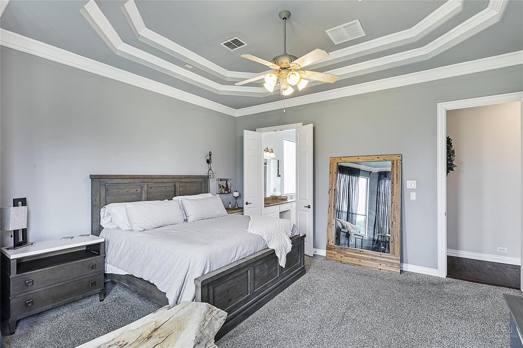671 Countryside Drive Fairview, TX 75069 - Photo 17 of 36 a spacious bedroom with a bed and a chandelier