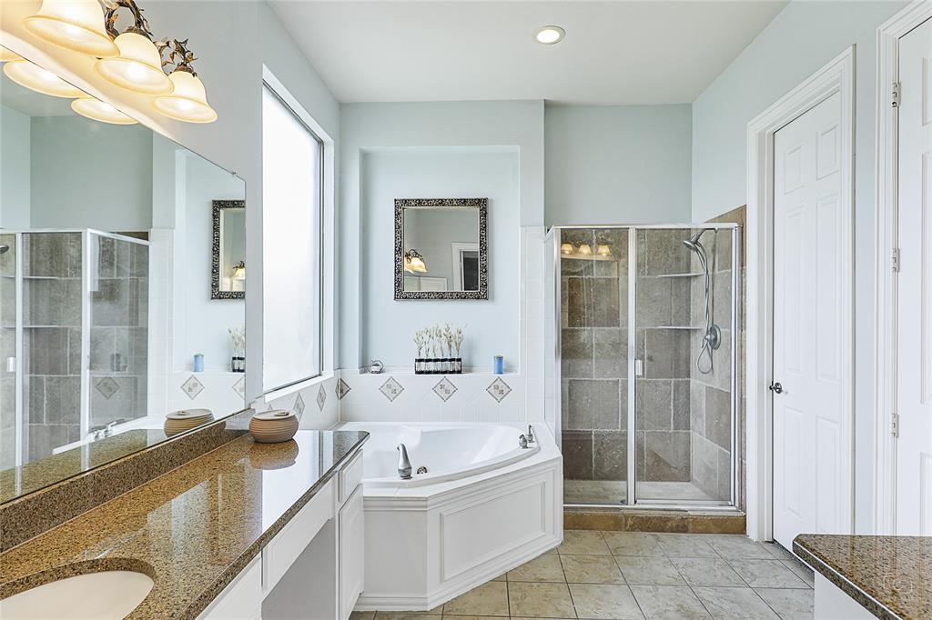671 Countryside Drive Fairview, TX 75069 - Photo 18 of 36 a bathroom with a tub a sink and mirror