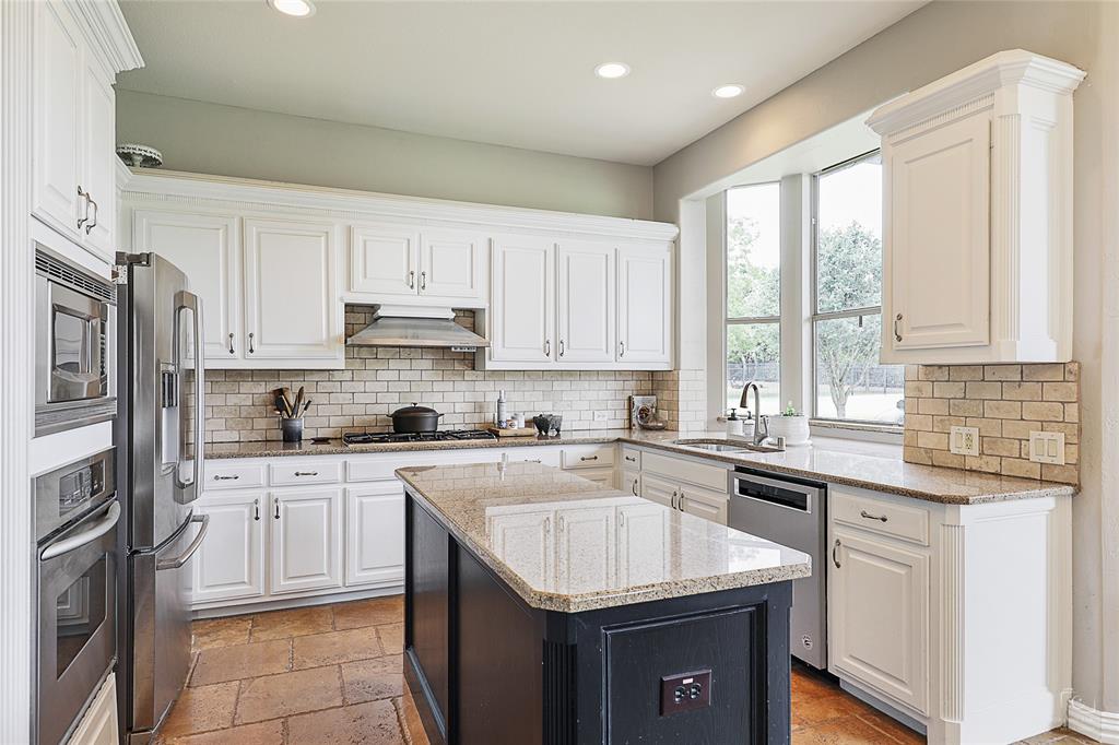 671 Countryside Drive Fairview, TX 75069 - Photo 6 of 36 a kitchen with a sink stove and cabinets