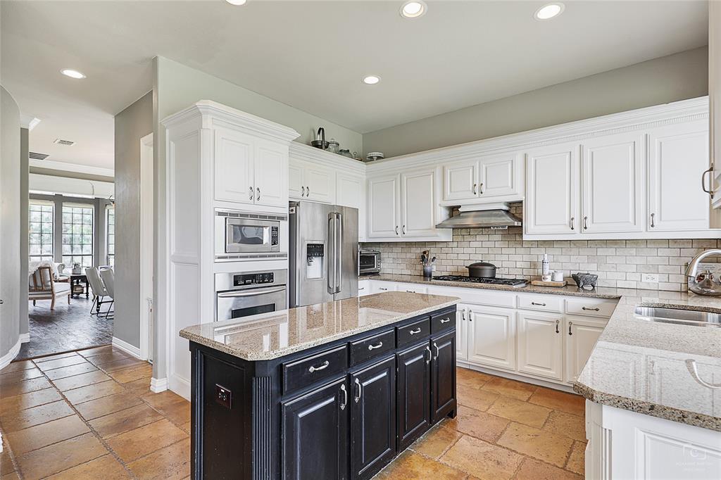 671 Countryside Drive Fairview, TX 75069 - Photo 7 of 36 a kitchen with a stove a sink a refrigerator and cabinets