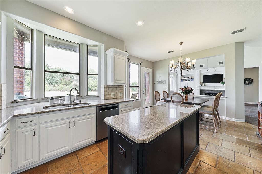 671 Countryside Drive Fairview, TX 75069 - Photo 8 of 36 a kitchen with sink cabinets and dining table