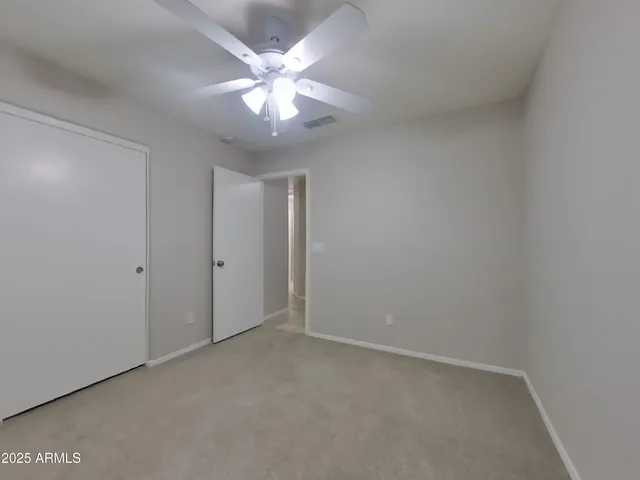 an empty room with a window and a fan