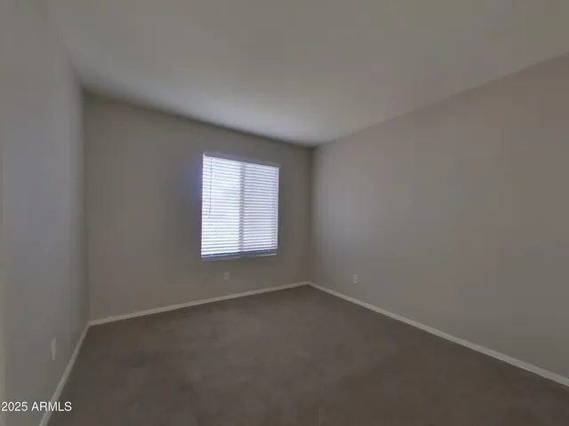 an empty room with a chandelier fan