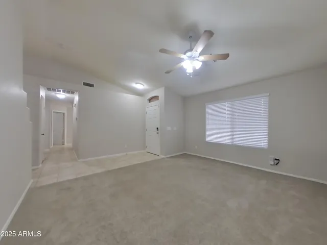 an empty room with a fan & a fan