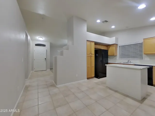 en empty room with windows and ceiling fan