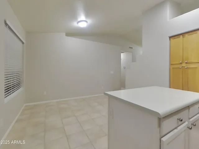 a view of a kitchen with an empty space and a window