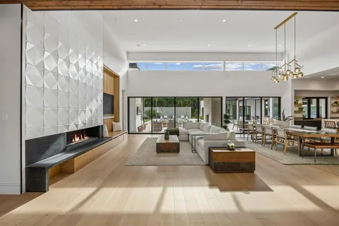 a living room with fireplace furniture and a large window