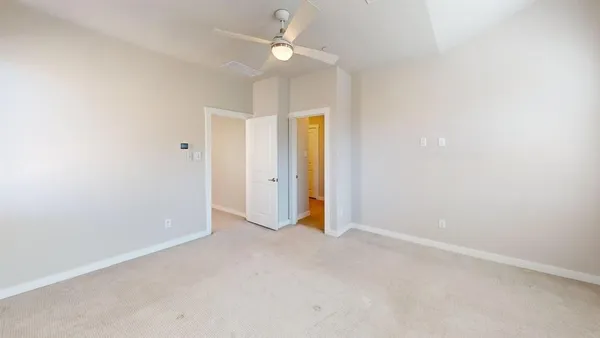 an empty room with a ceiling fan and a window