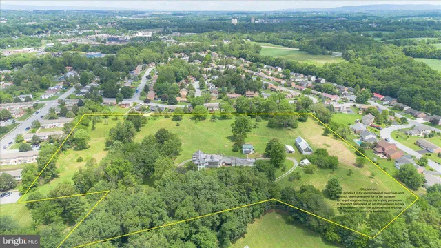 an aerial view of residential houses with outdoor space and trees