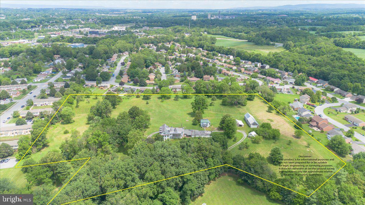 an aerial view of residential houses with outdoor space and trees