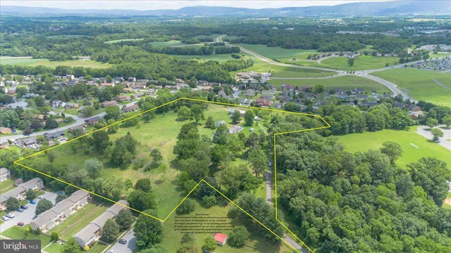 an aerial view of residential houses with outdoor space and trees