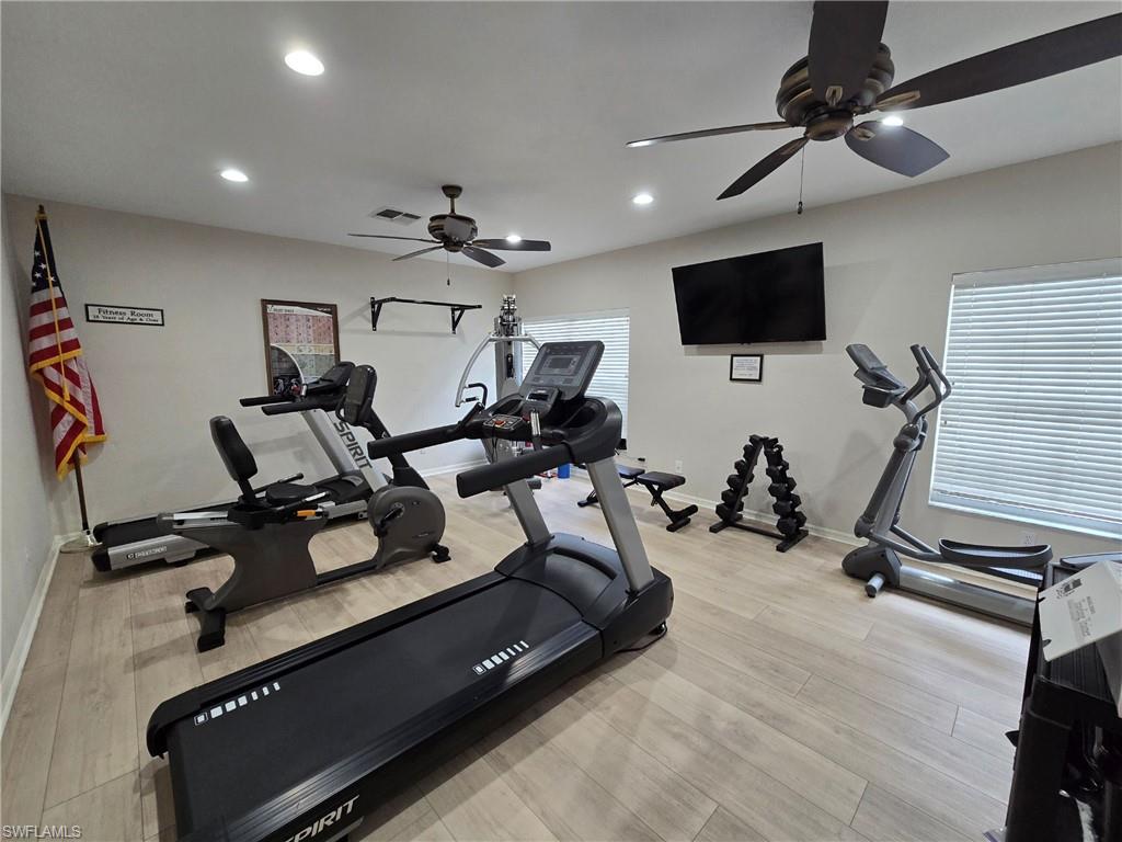 7436 Plumbago Bridge Road, Unit N202 Naples, FL 34109 - Photo 18 of 24 a room with gym equipment and a flat screen tv