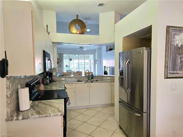 a kitchen with refrigerator and cabinets