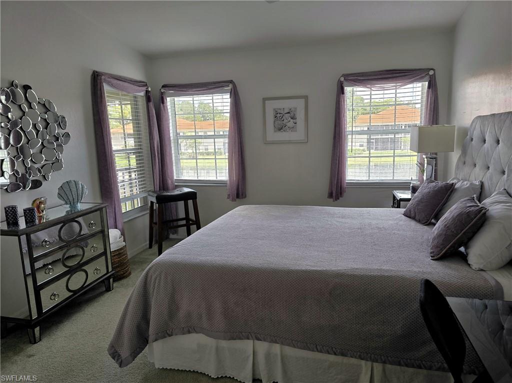 7436 Plumbago Bridge Road, Unit N202 Naples, FL 34109 - Photo 6 of 24 a bedroom with a bed a dresser with windows