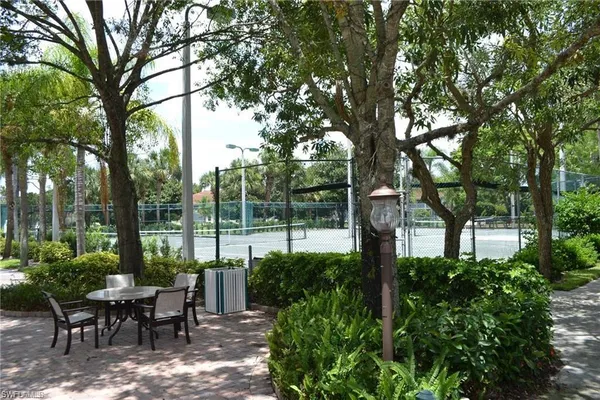 a view of a patio with table and chairs and a large tree