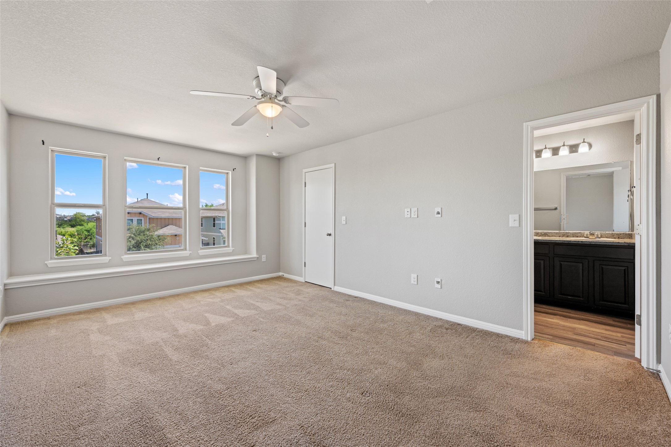 124 Guemal Road Buda, TX 78610 - Photo 28 of 40 A comfortable bedroom features multiple windows providing abundant light and an attached private bath.