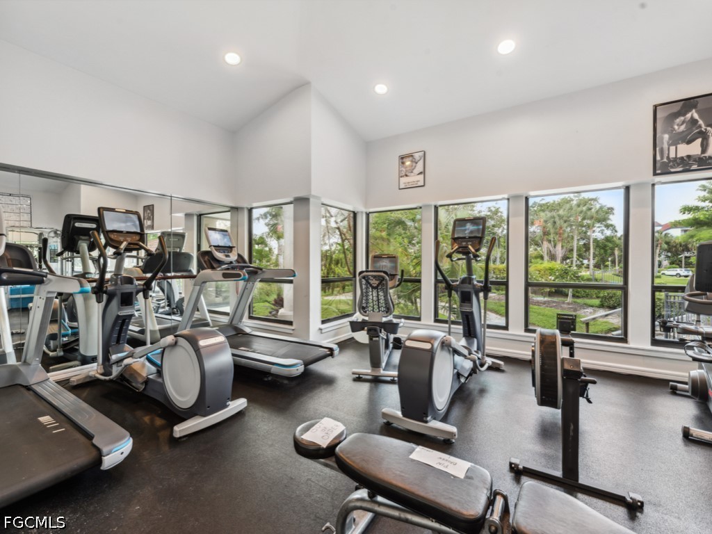 232 La Peninsula Boulevard, Unit 232 Naples, FL 34113 - Photo 43 of 44 a room with gym equipment and floor to ceiling window