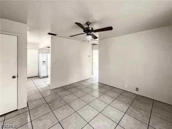 a view of a livingroom with a chandelier fan and windows