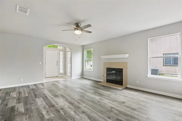 an empty room with a window and a fan