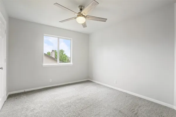 an empty room with a fan and a ceiling fan