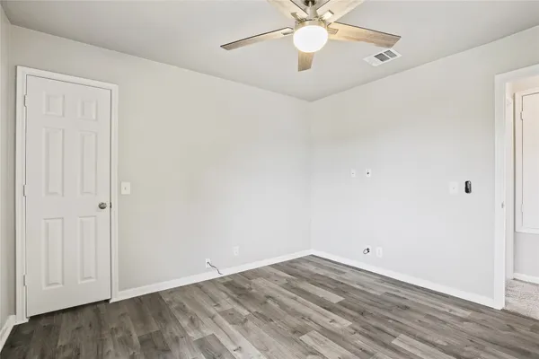 a view of an empty room with wooden floor