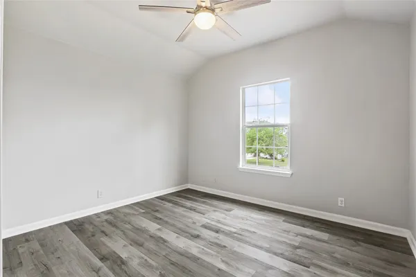 a view of an empty room and a ceiling fan window