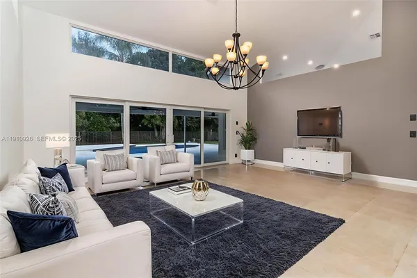 a living room with furniture a dining table and a chandelier