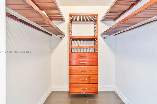 a view of walk in closet with clothes