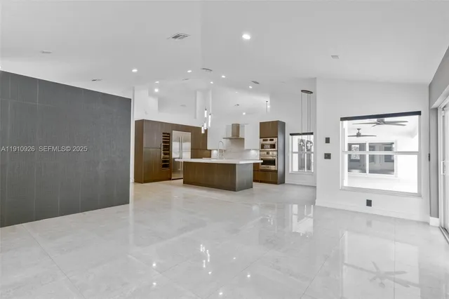 a view of kitchen with kitchen island and stainless steel appliances