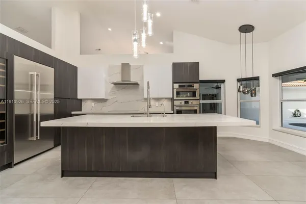 a large kitchen with kitchen island a sink stainless steel appliances and cabinets