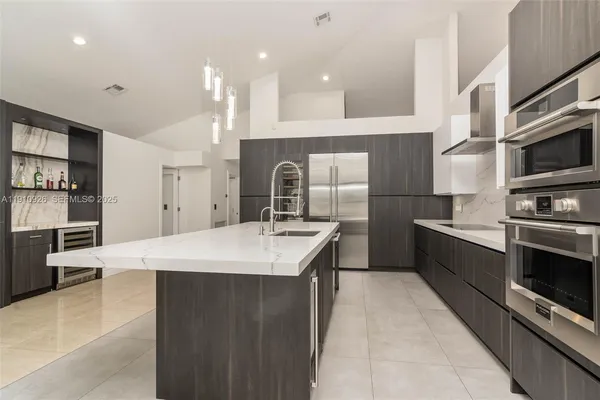 a large kitchen with a large counter top stainless steel appliances and cabinets