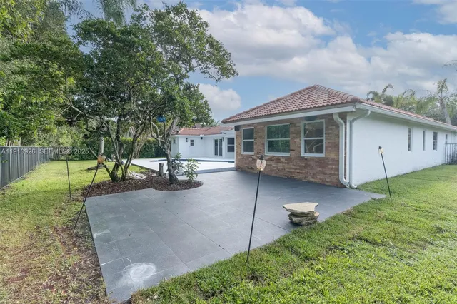 a view of a house with backyard and sitting area