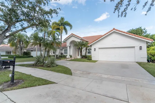 a front view of a house with a yard and a garage