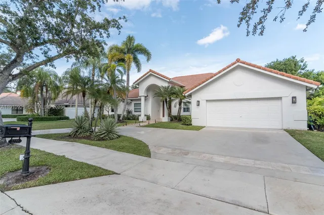 a front view of a house with a yard and a garage