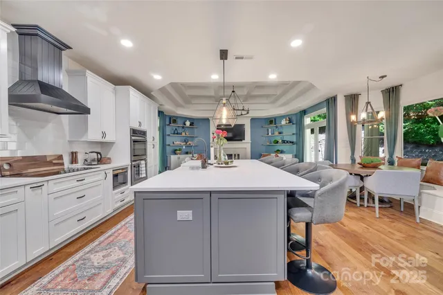 a kitchen with a stove a refrigerator and chairs