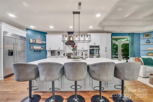 a view of kitchen with dining area refrigerator and wooden floor