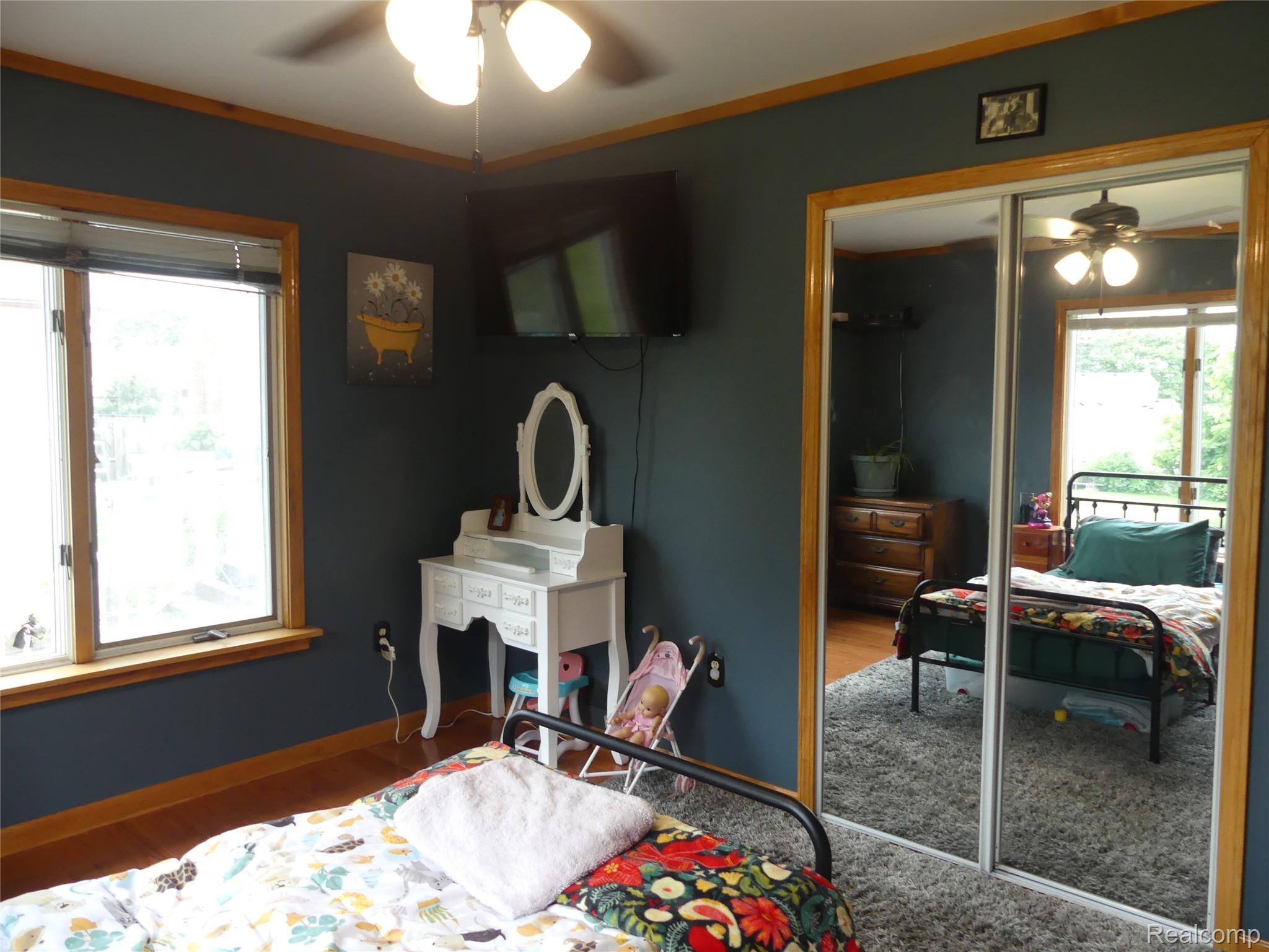 8335 Pardee Road Taylor, MI 48180 - Photo 19 of 23 Wood-finish flooring, ceiling fan with light fixture, and mirrored closet doors