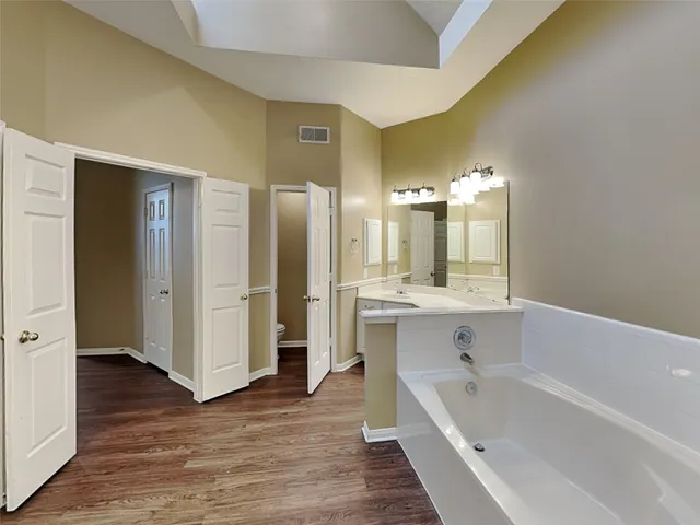 a bathroom with a large tub shower and sink