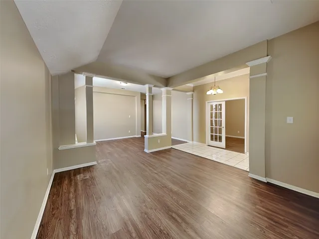 a view of a big room with wooden floor and windows