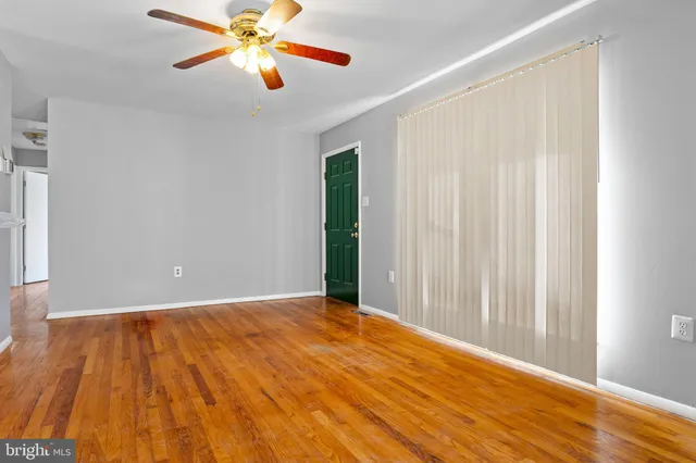 a view of a room with a wooden floor and a ceiling fan