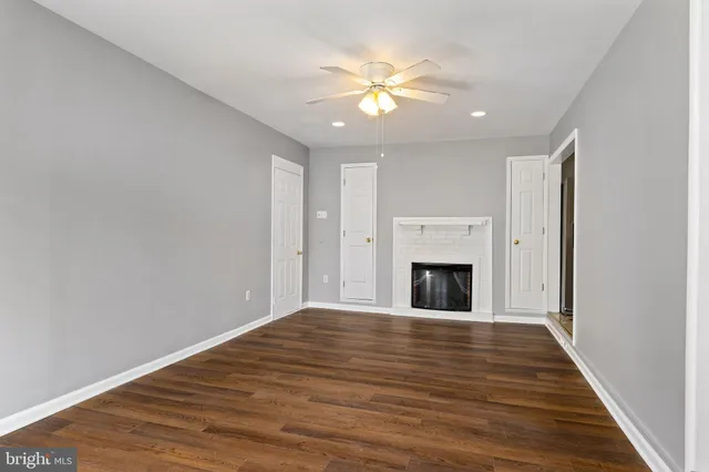 a view of a livingroom with wooden floor and a ceiling fan