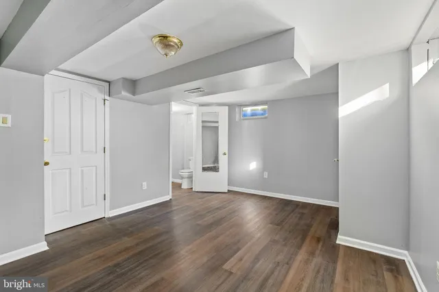 a view of an empty room with wooden floor
