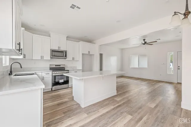 a kitchen with white cabinets and appliances