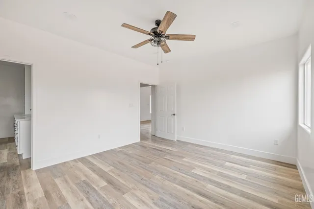 a view of a room with wooden floor and a ceiling fan