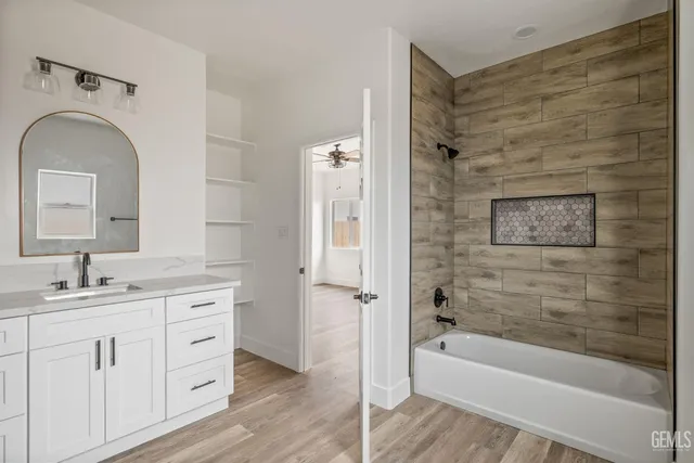 a bathroom with a granite countertop sink a mirror bathtub and shower