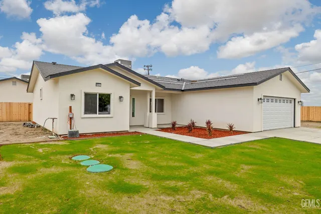 a view of a house with a yard and sitting area