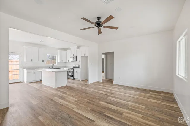 a view of a kitchen with wooden floor and windows