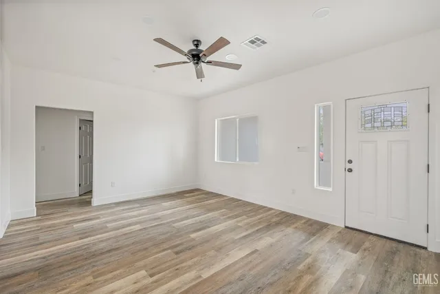 a view of a big room with wooden floor and windows in a room
